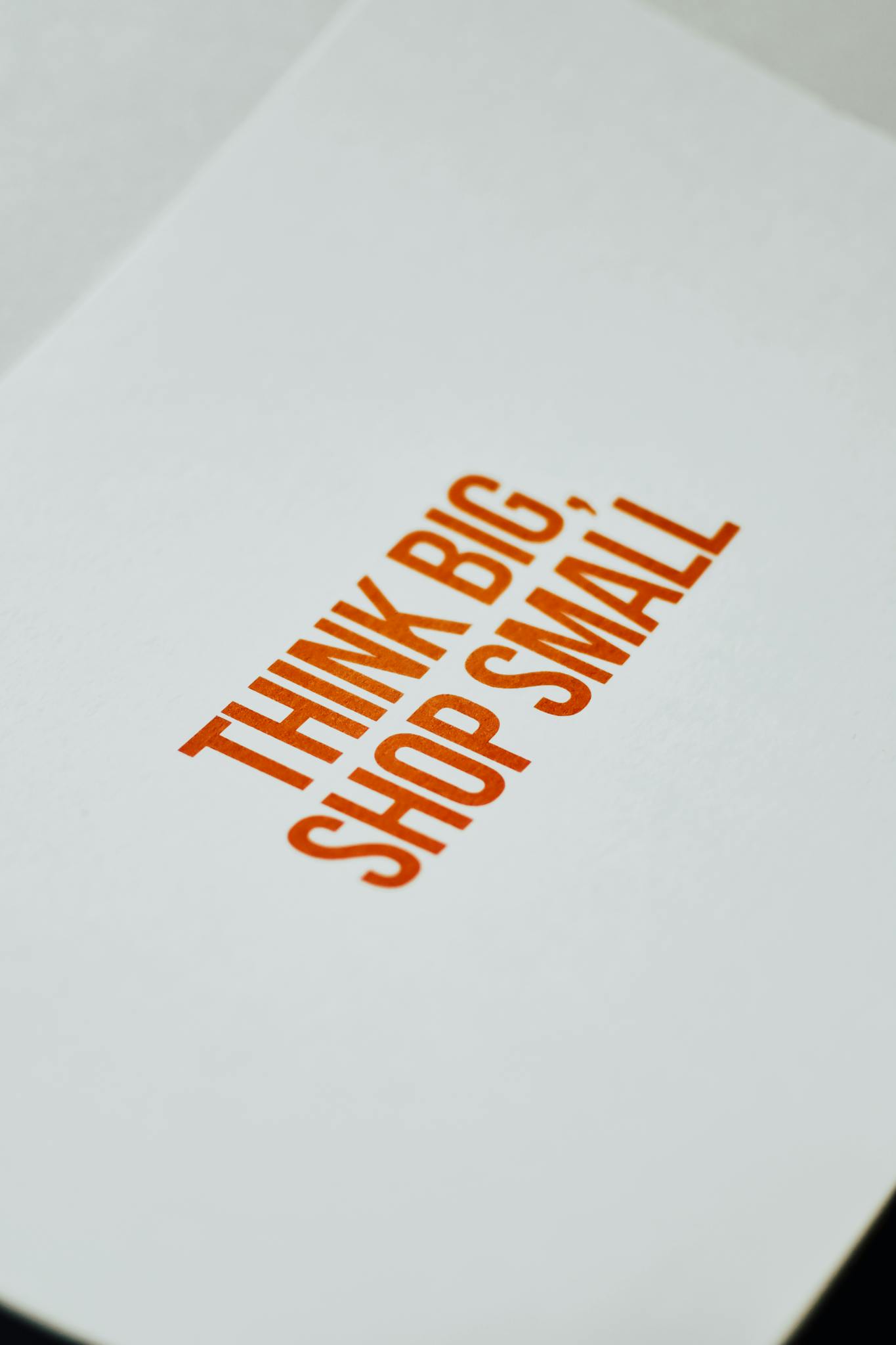 Close-up of paper sign with 'Think Big, Shop Small' for support and strategy.